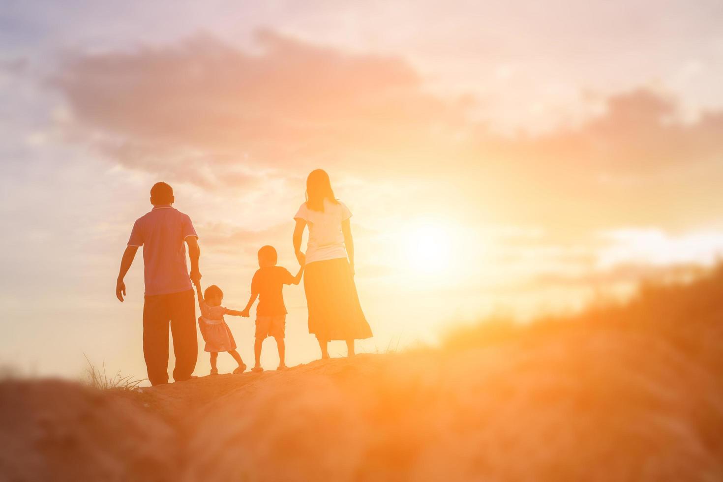 familia feliz bailando en la carretera al atardecer. fiesta nocturna en la naturaleza foto