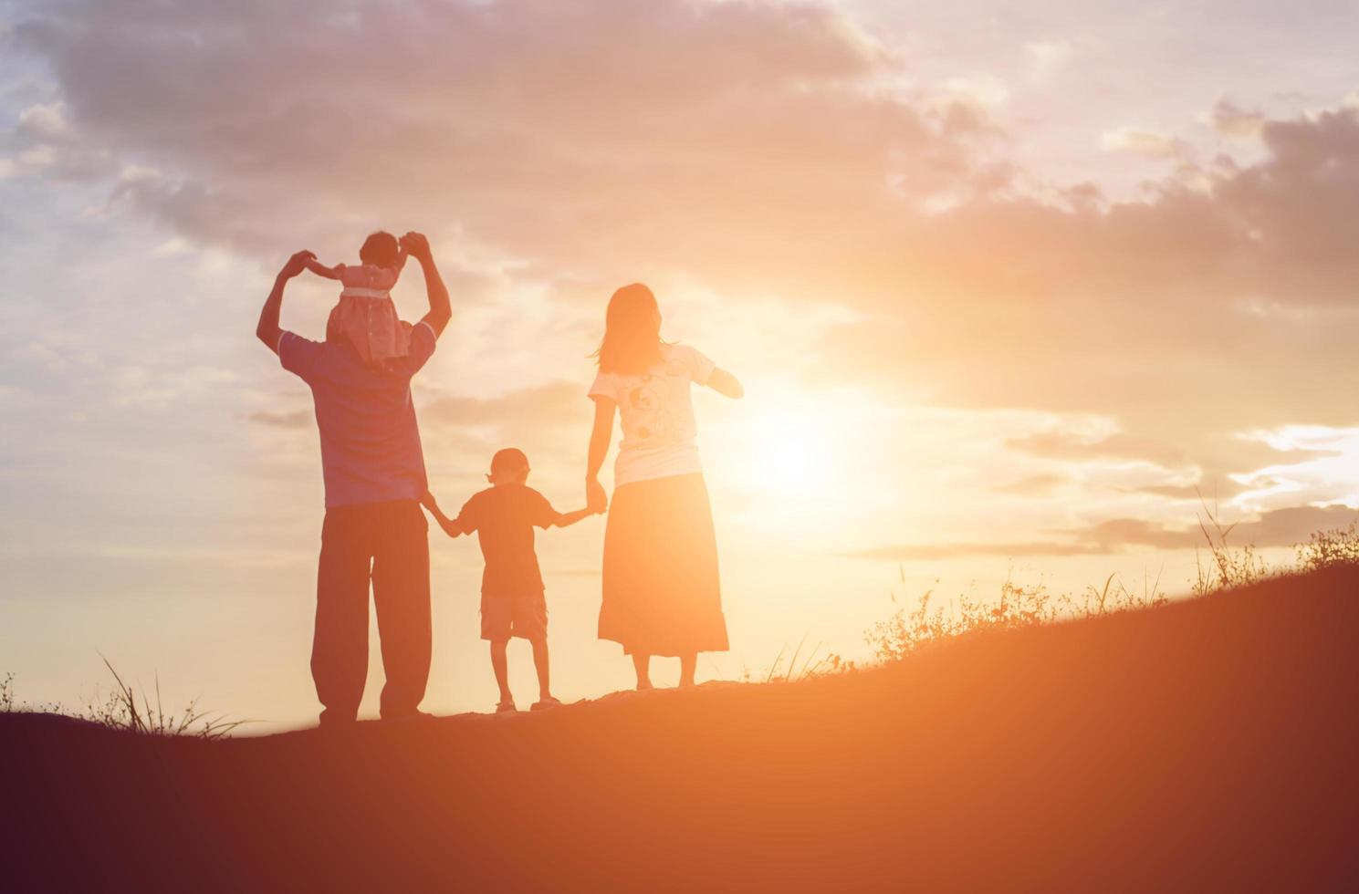 familia feliz bailando en la carretera al atardecer. fiesta nocturna en la naturaleza foto