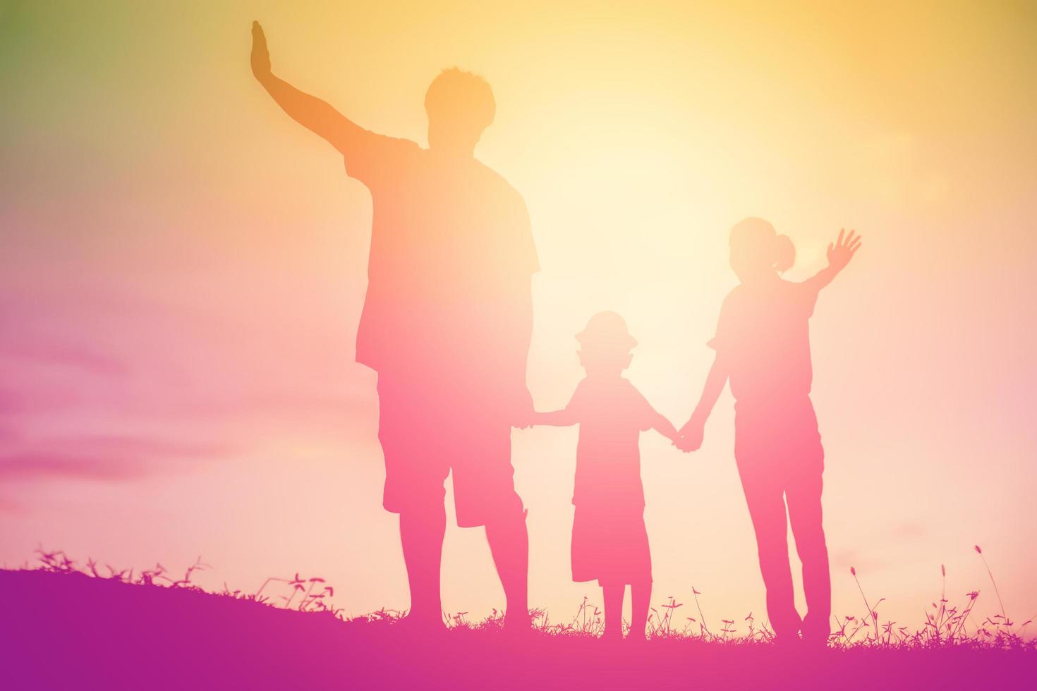 silueta de una familia feliz y feliz puesta de sol foto