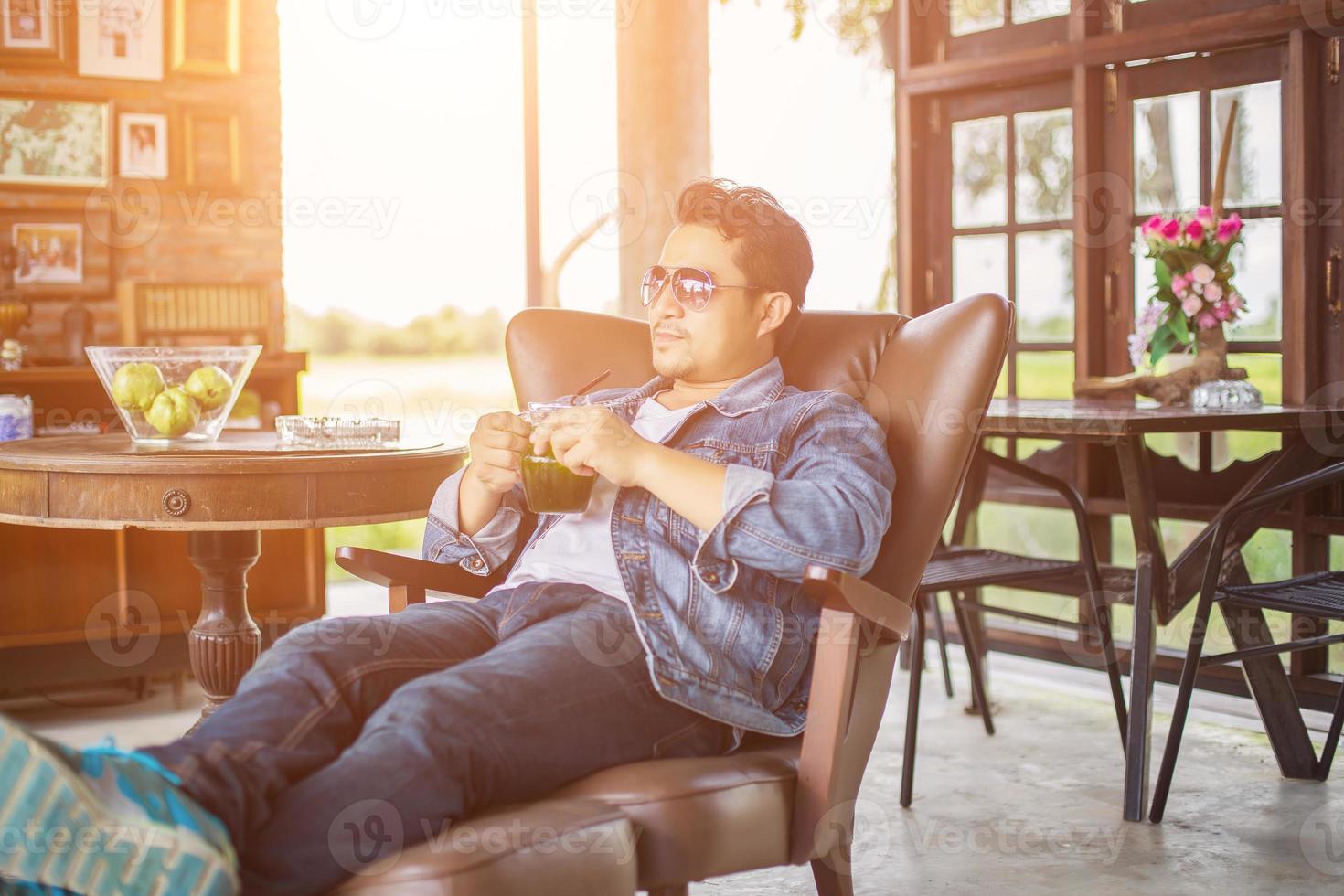 joven con smartphone sonriendo relajándose en el café. foto