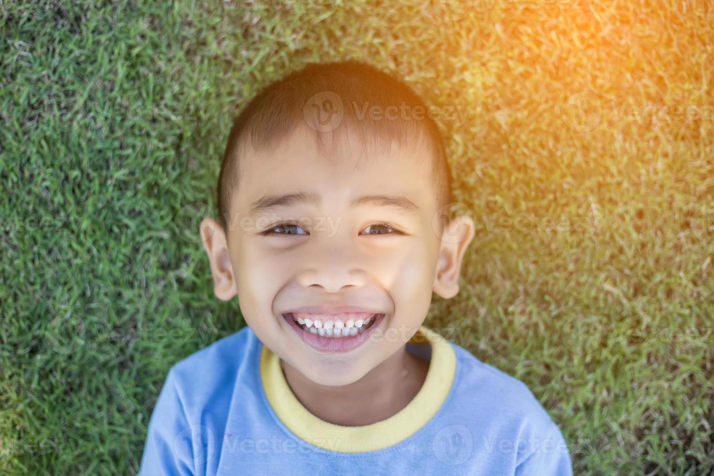 Happy mulatto boy child is smiling enjoying adopted life. Portrait of young boy in nature, park or outdoors. Concept of happy family or successful adoption or parenting. photo