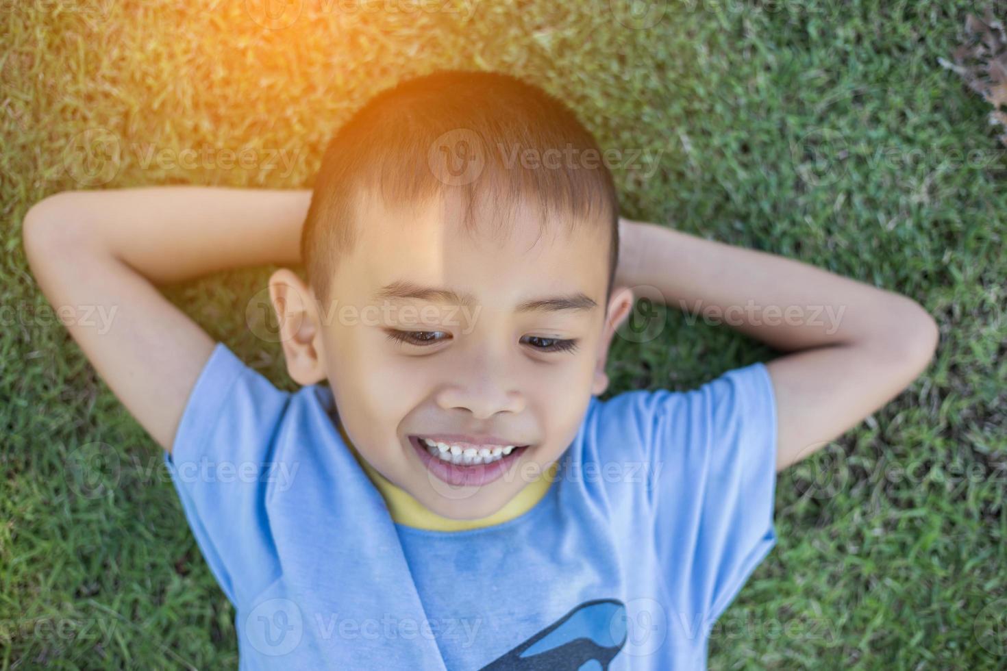 Happy mulatto boy child is smiling enjoying adopted life. Portrait of young boy in nature, park or outdoors. Concept of happy family or successful adoption or parenting. photo