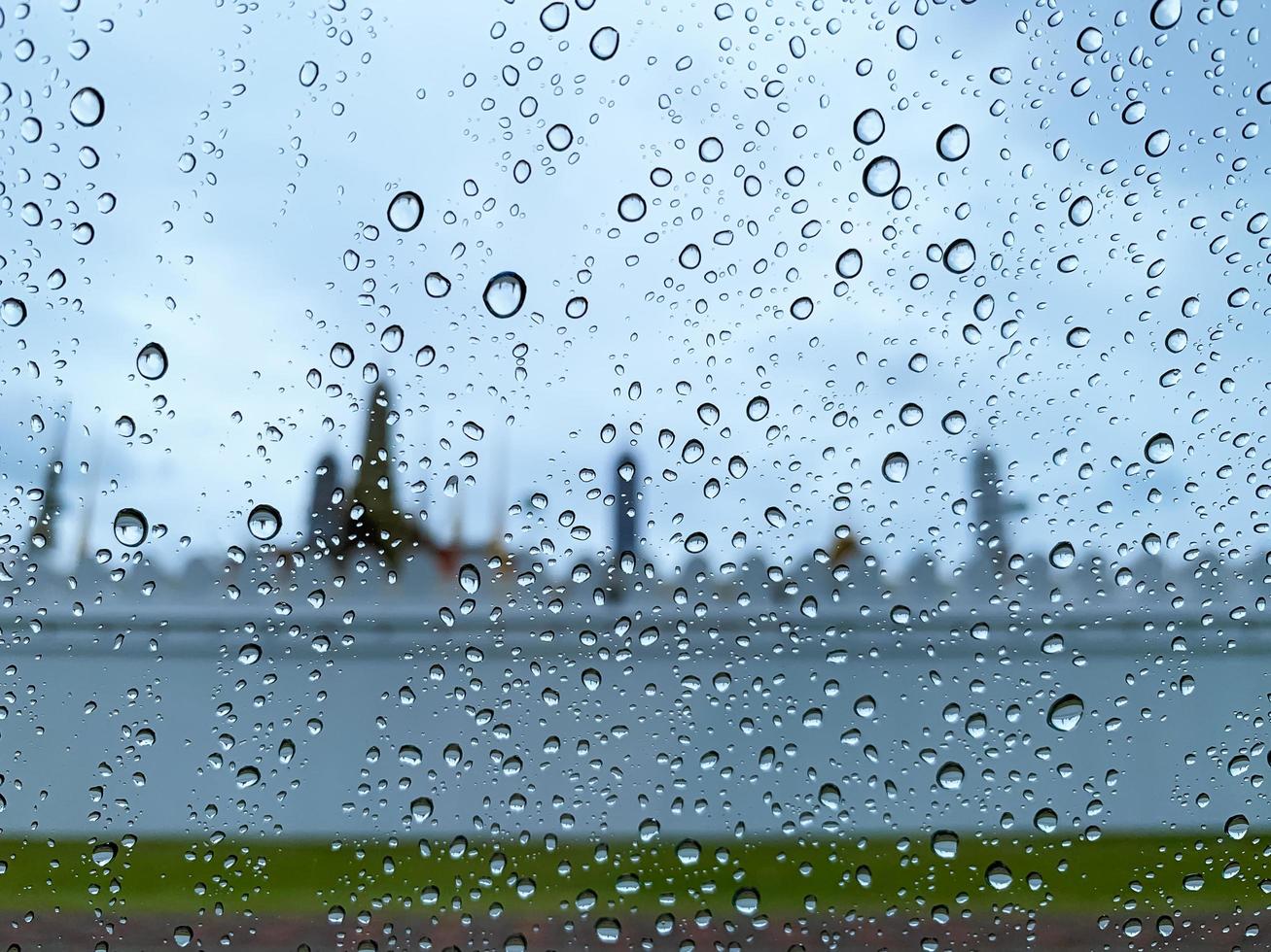 gota de agua en el cristal del coche cuando llueve en temporada de monzones con fondo borroso. foto