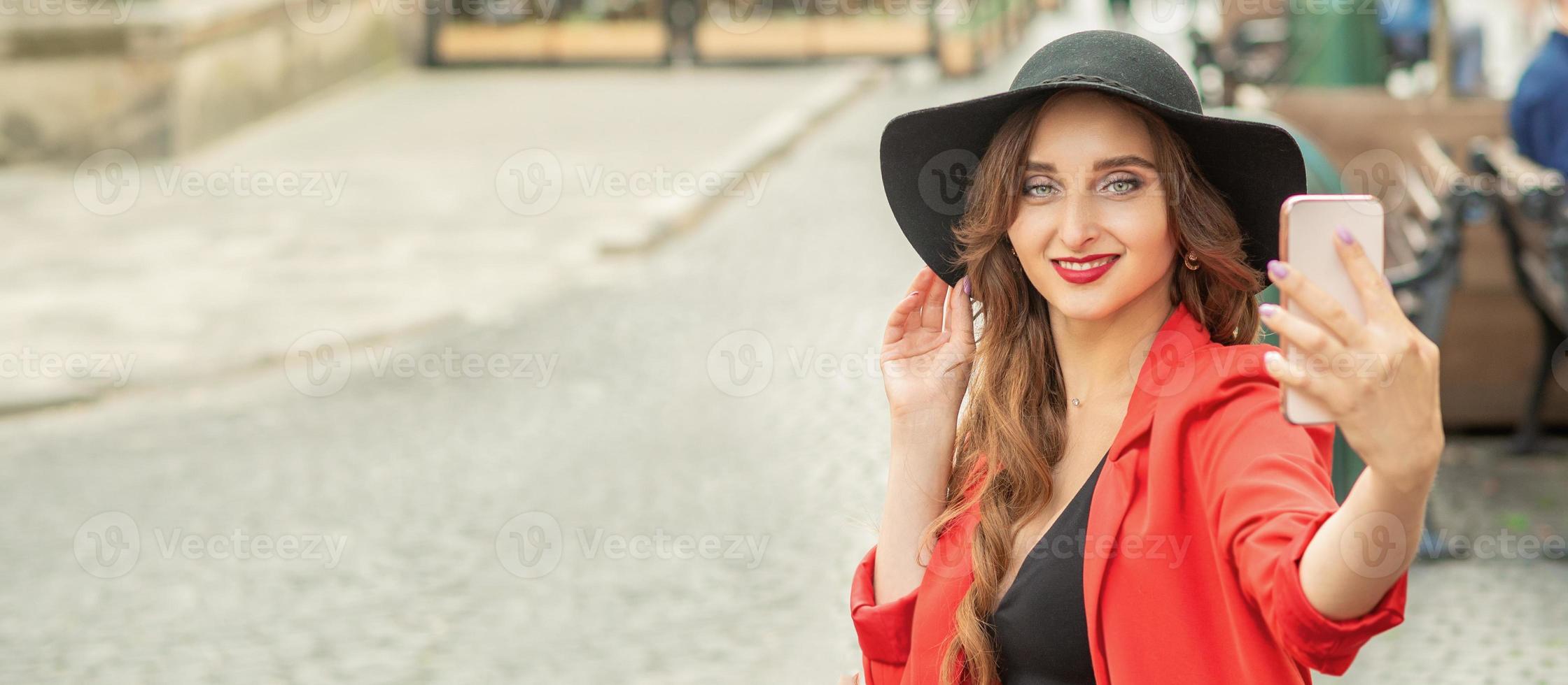 Pretty tourist girl is taking a selfie. photo