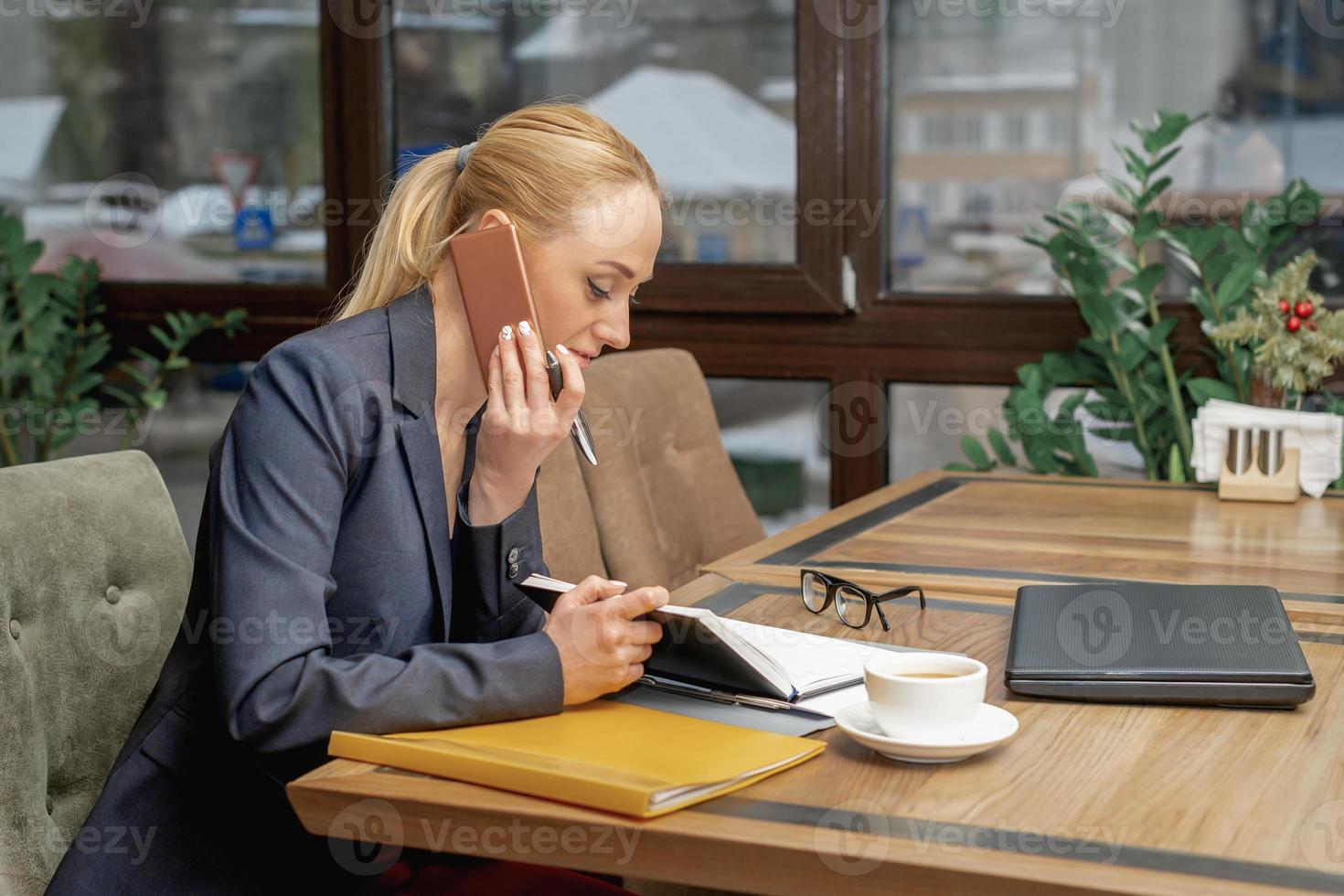 Young woman is talking by cell phone in office. photo