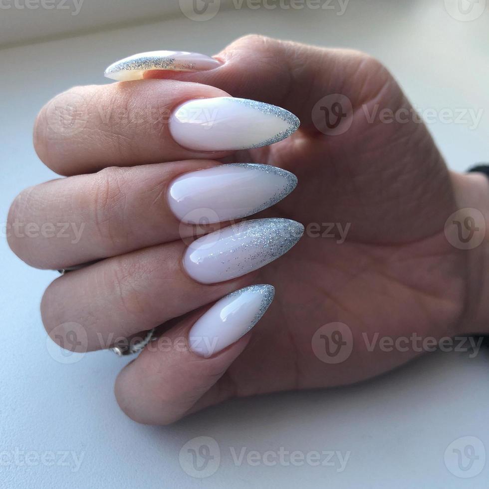 elegante manicura rosa femenina de moda. manos de una mujer con manicura rosa en las uñas foto