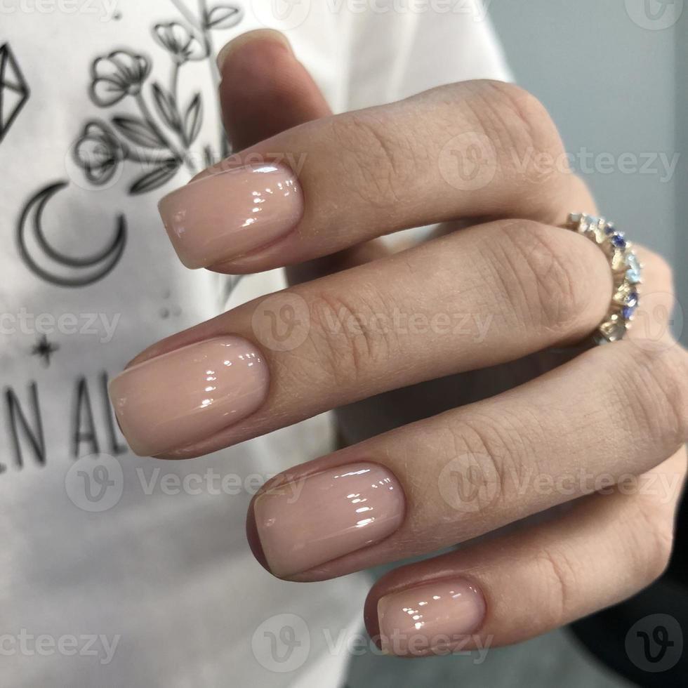 elegante manicura natural femenina de moda. manos de una mujer con manicura natural en las uñas foto