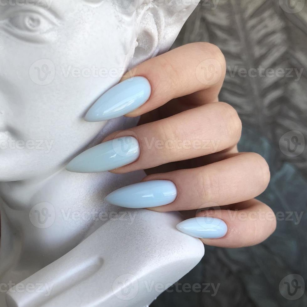 Stylish trendy female blue manicure with design.Hands of a woman with blue manicure on nails photo