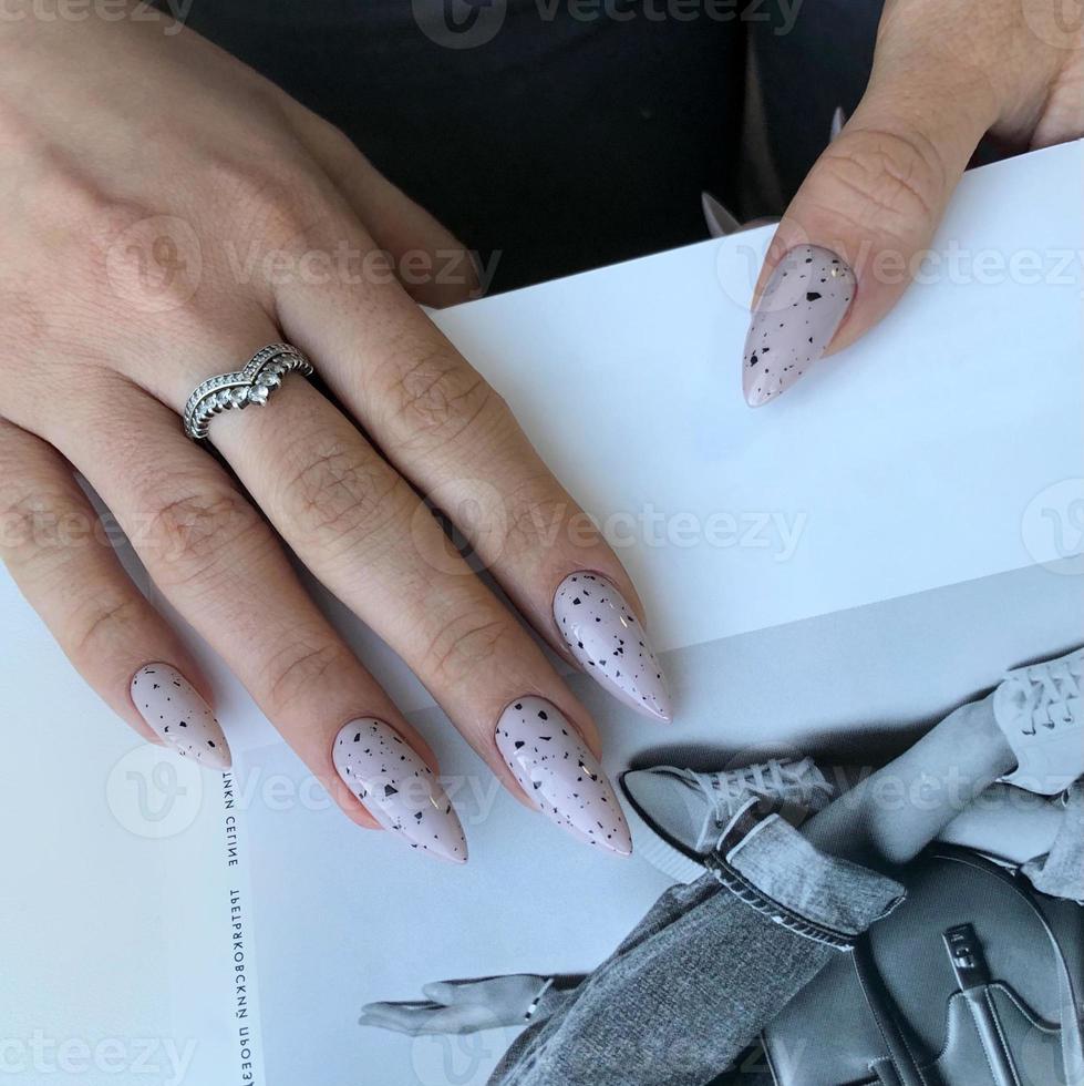 manicura gris de mujer con diseño.manos de una mujer con manicura gris en las uñas foto