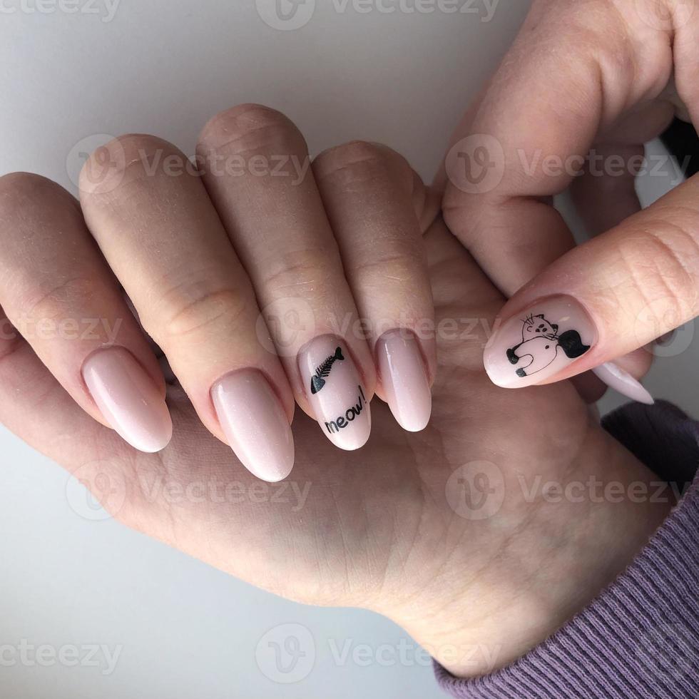 manicura femenina con gato.manos de una mujer con manicura de gato en las uñas foto