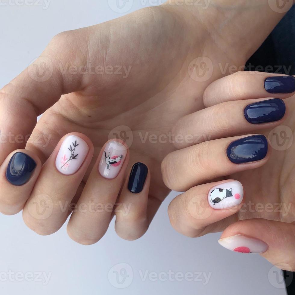 Stylish trendy female blue manicure with design.Hands of a woman with blue manicure on nails photo