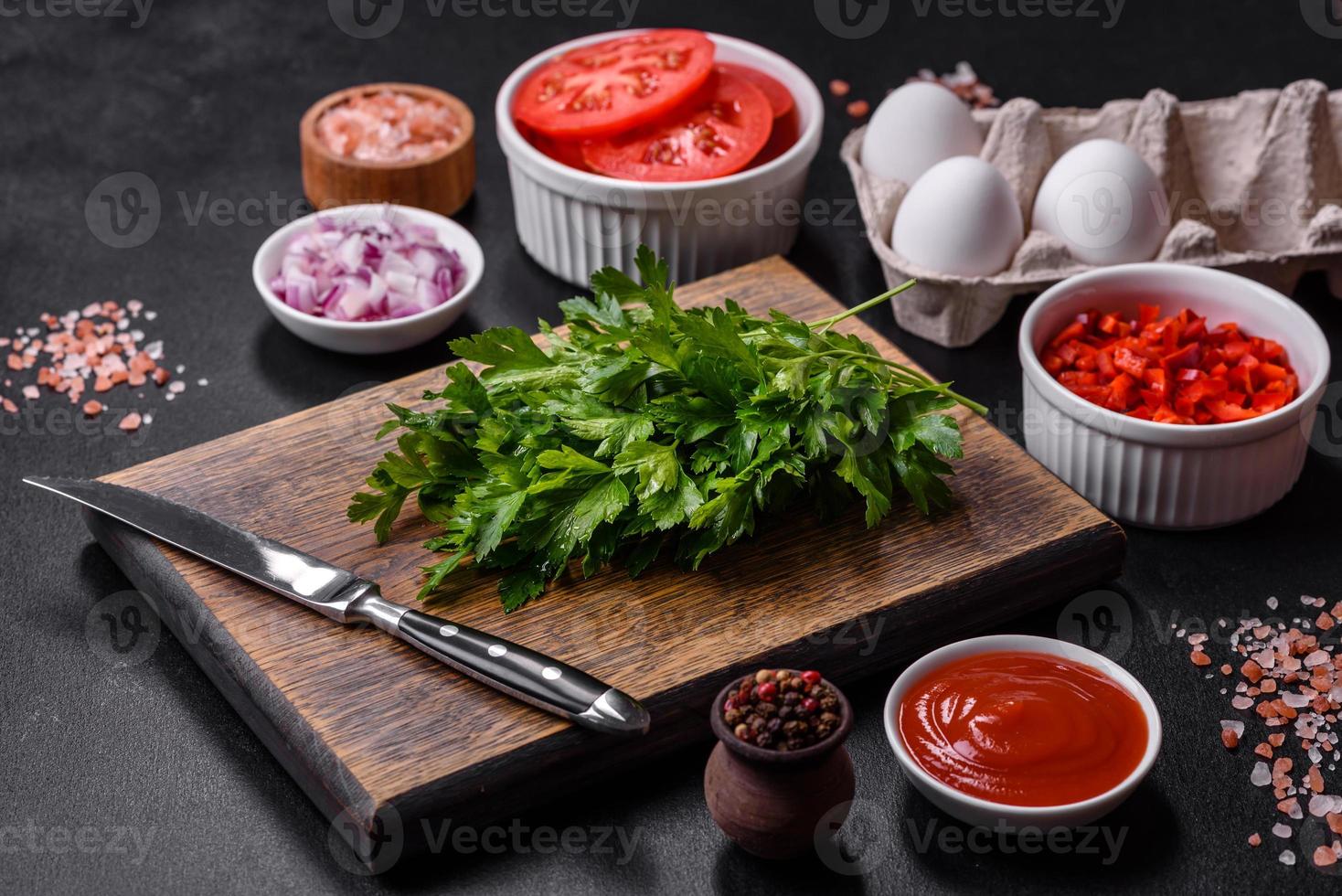 Ingredients for making shakshuka, dishes with fried eggs with tomato sauce, spices and herbs photo
