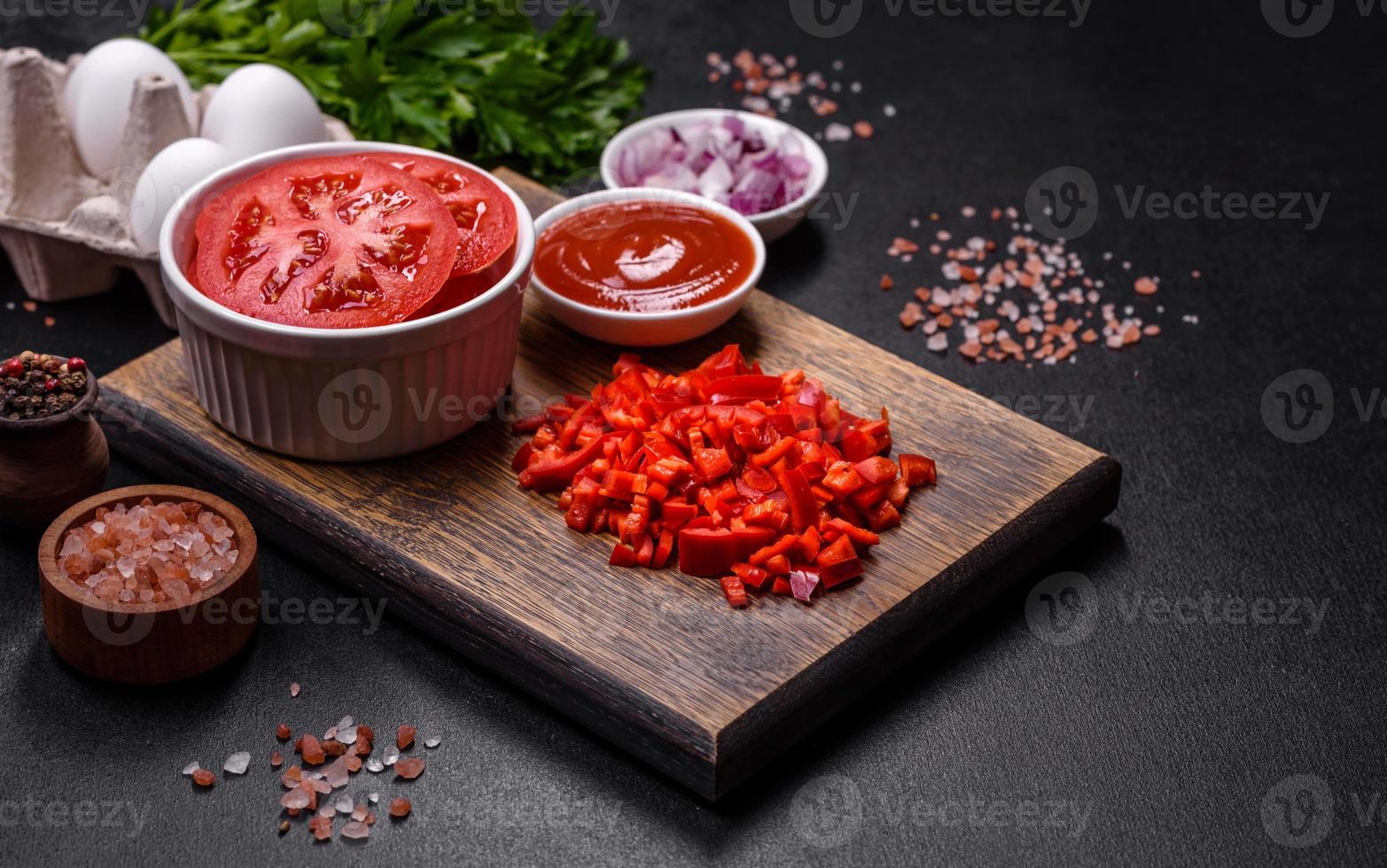 Ingredients for making shakshuka, dishes with fried eggs with tomato sauce, spices and herbs photo