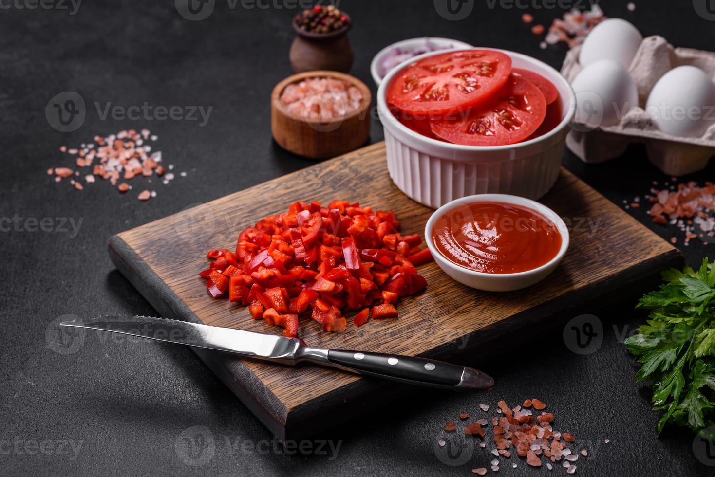 Ingredients for making shakshuka, dishes with fried eggs with tomato sauce, spices and herbs photo