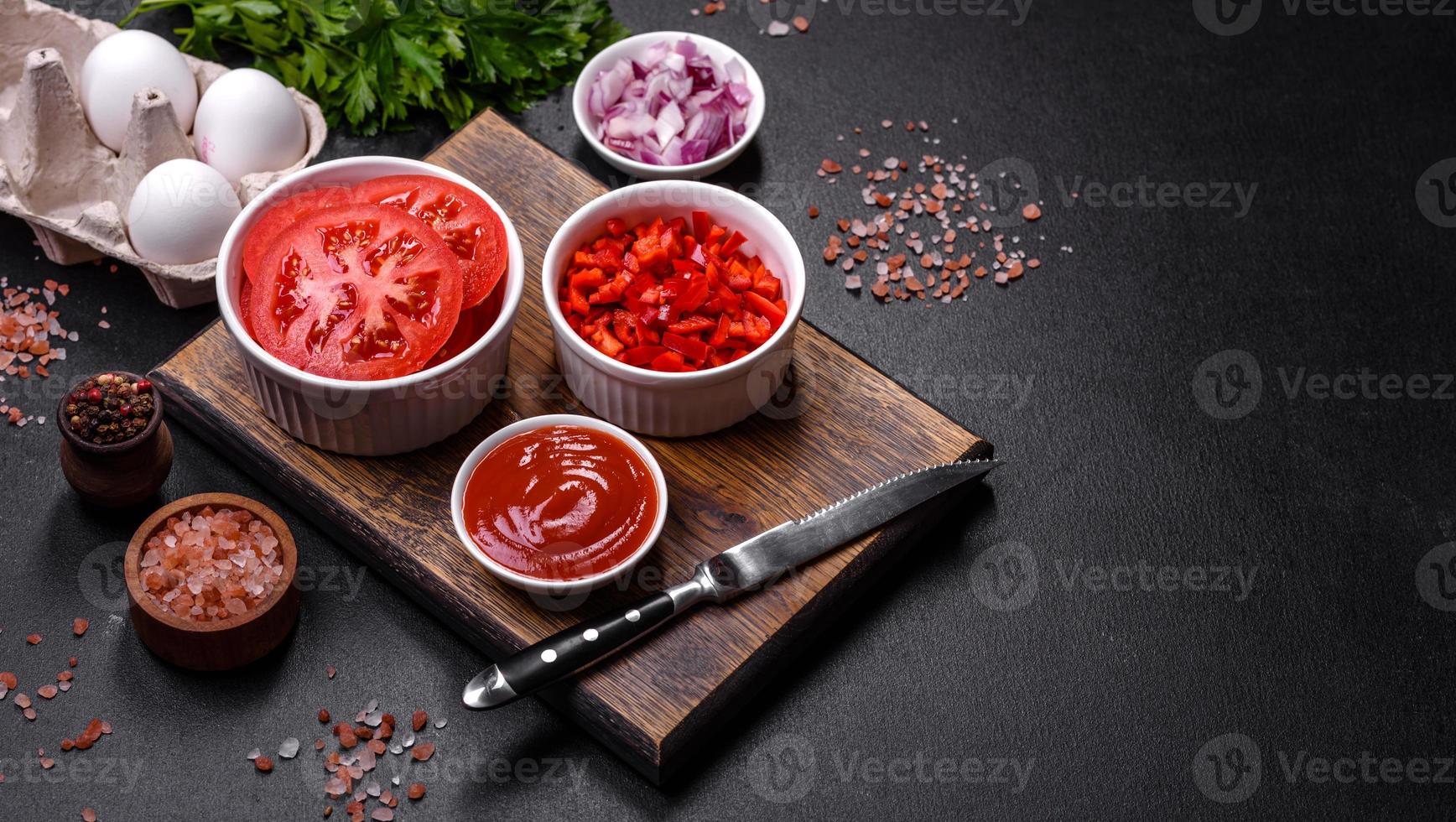 Ingredients for making shakshuka, dishes with fried eggs with tomato sauce, spices and herbs photo