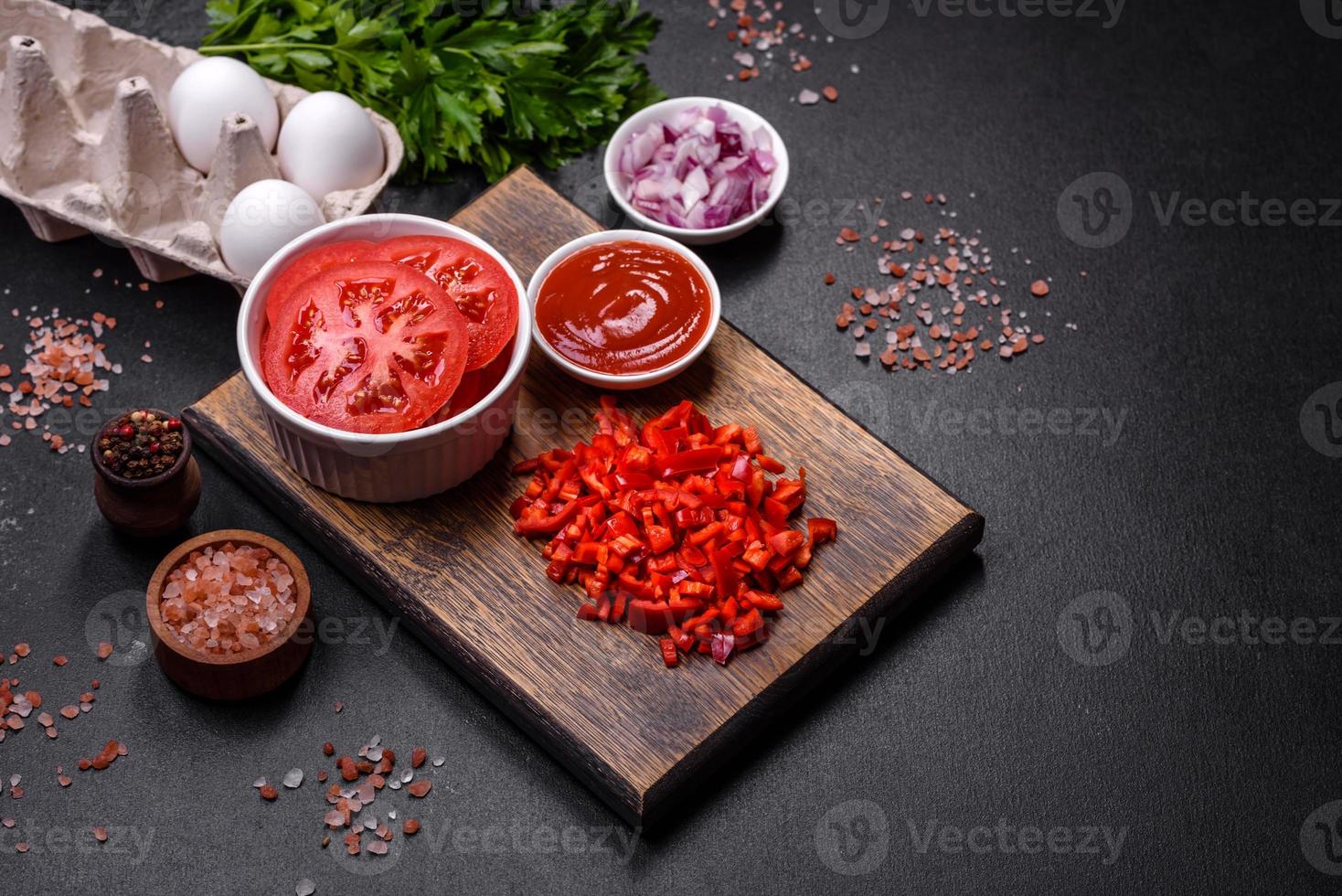 Ingredients for making shakshuka, dishes with fried eggs with tomato sauce, spices and herbs photo