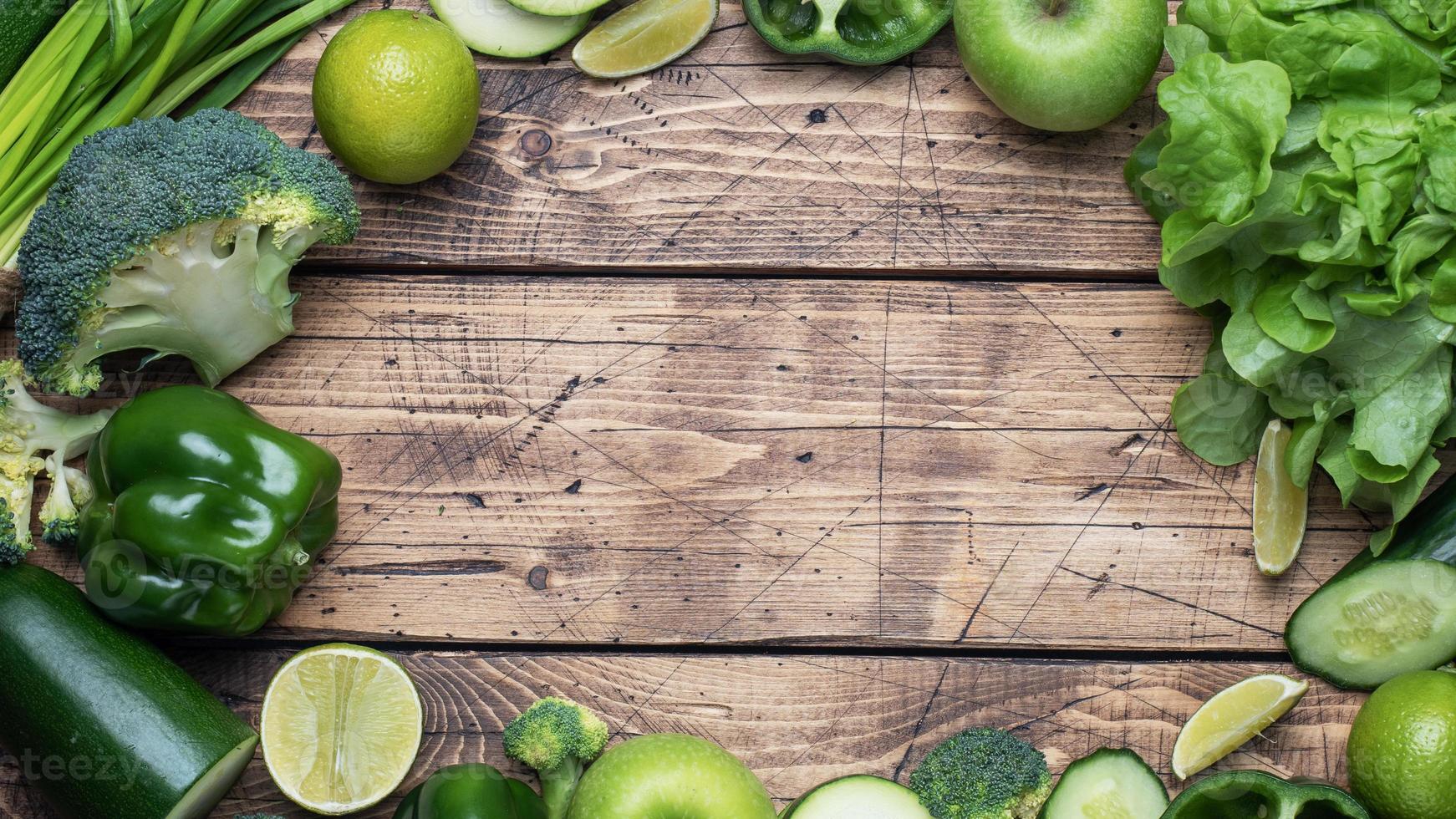 Frame Fresh green vegetables and herbs on a wooden background. Copy space. photo