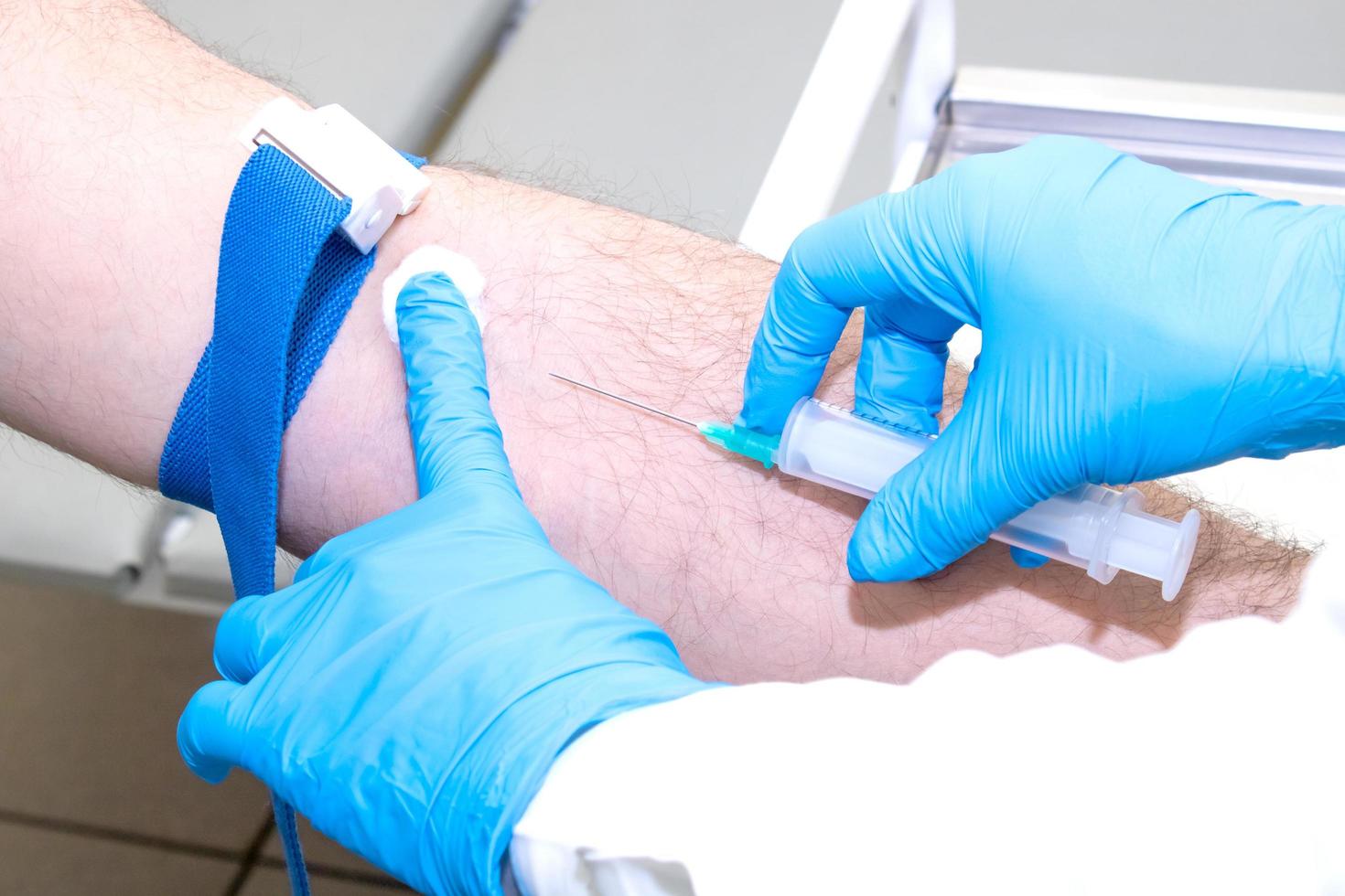 a nurse takes blood from a vein for analysis photo