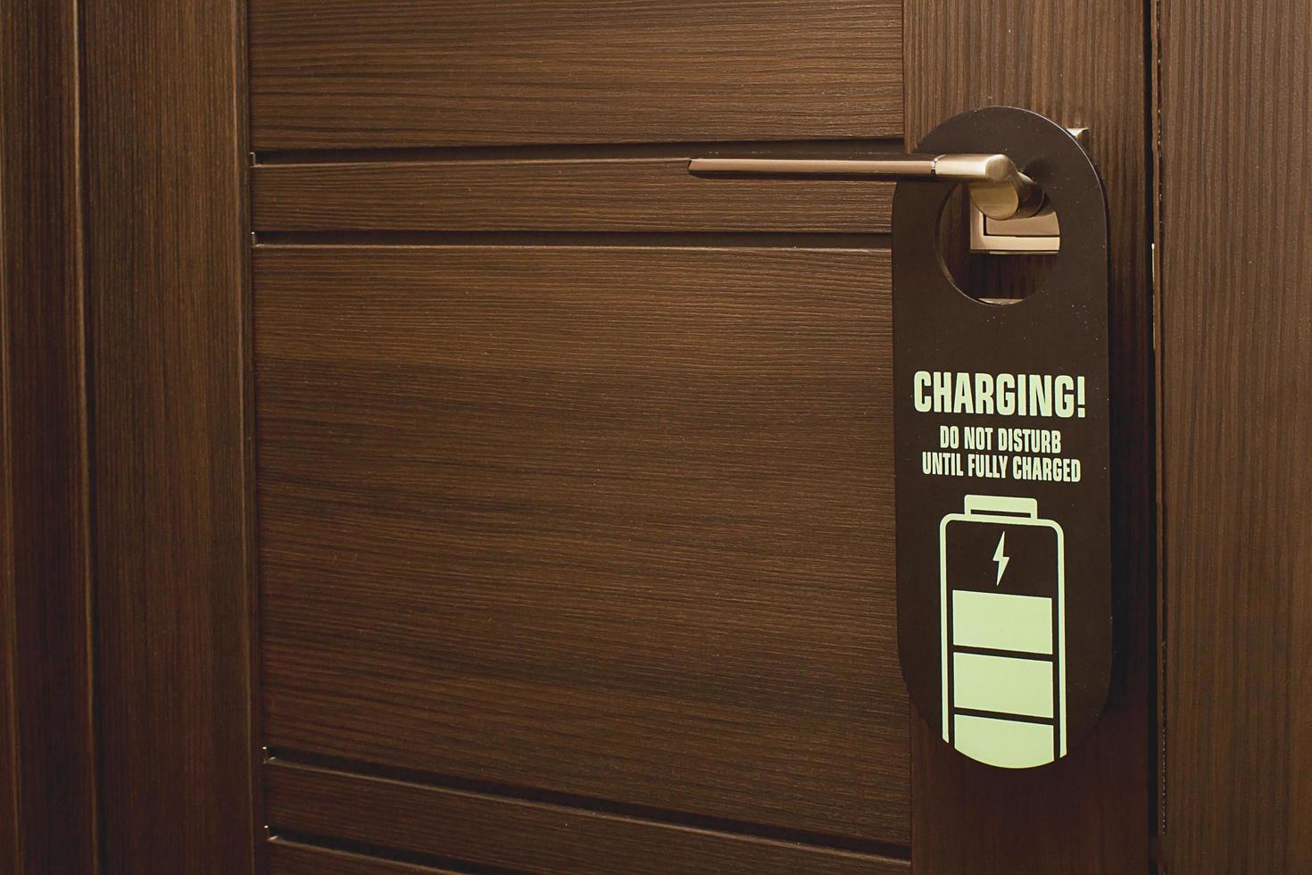 there is a sign on the door Charging Do not disturb until fully charged. photo