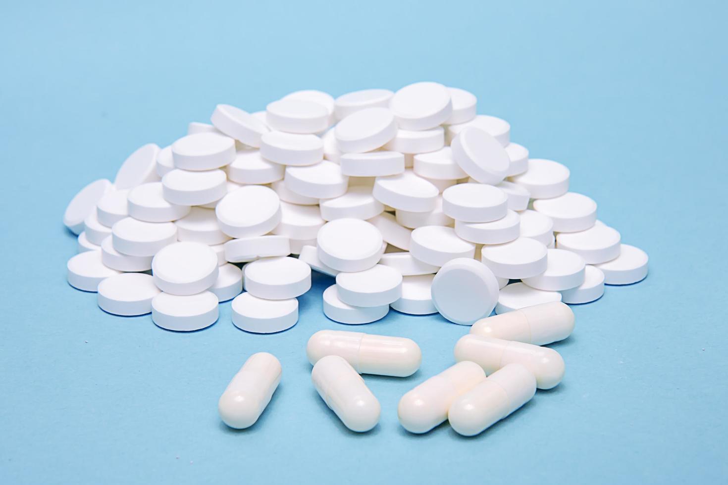 A lot of pills laid out in a slide on a blue background photo