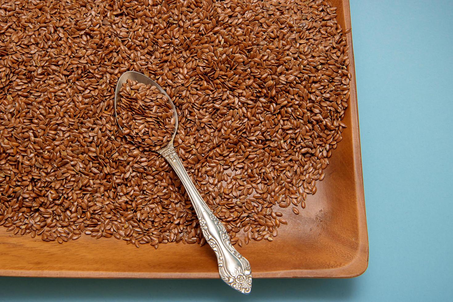 Flax seeds in a wooden bowl with a spoon. photo