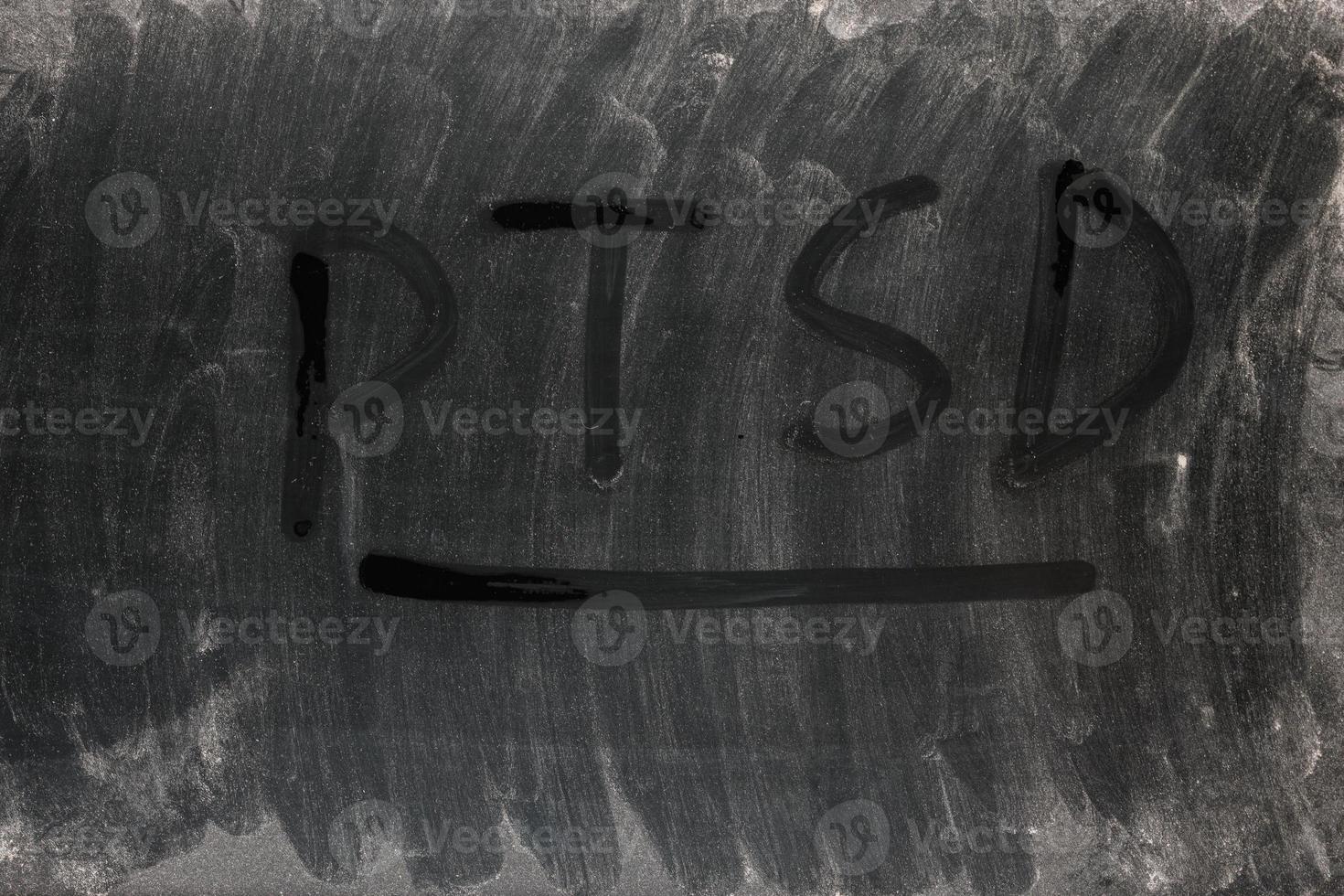 the word PTSD - post traumatic stress disorder handwritten on full frame background and texture of dusty black surface of an old LCD screen photo