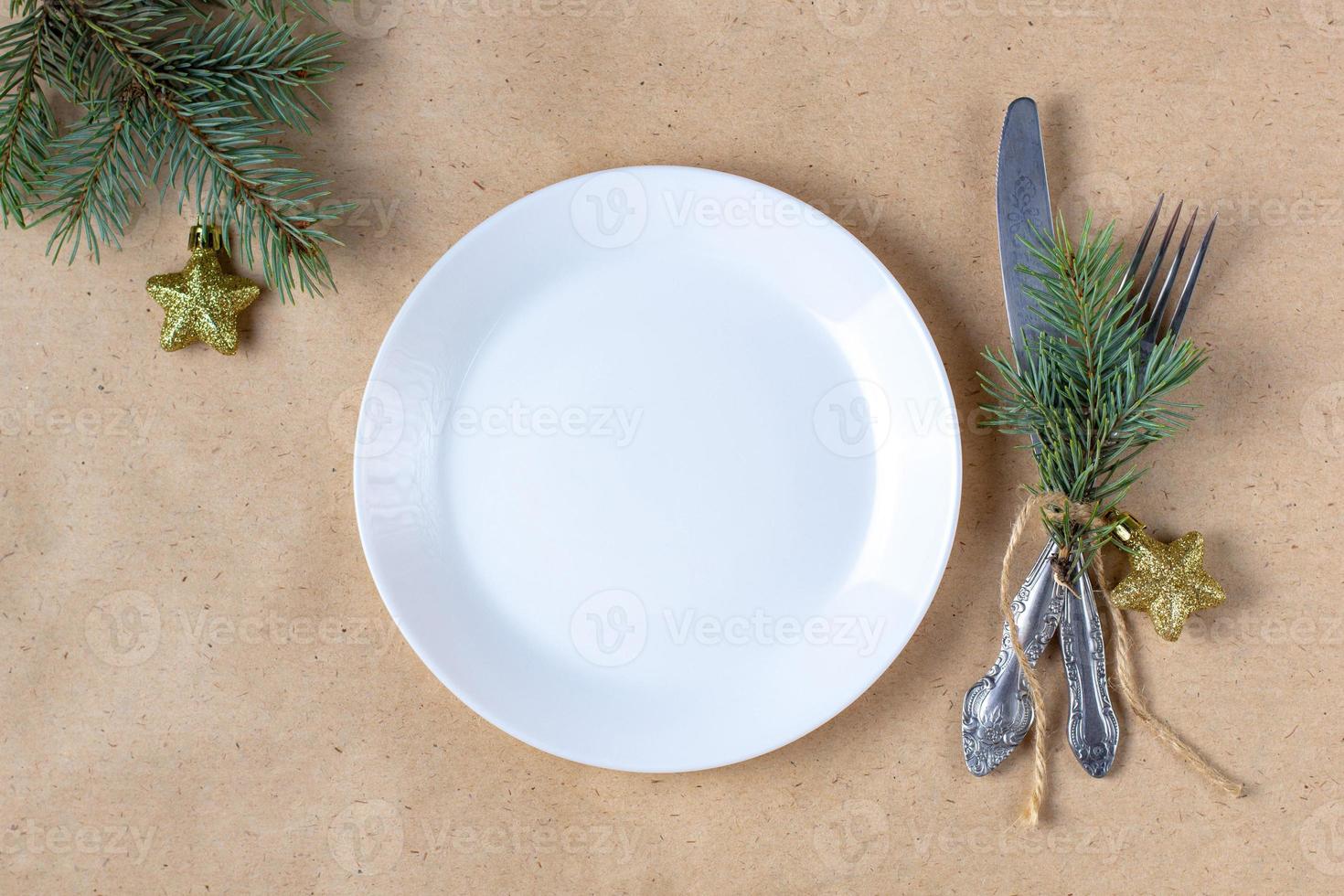 Holiday table setting with branch of christmas tree, empty plate and decorations. New year flat lay food concept photo