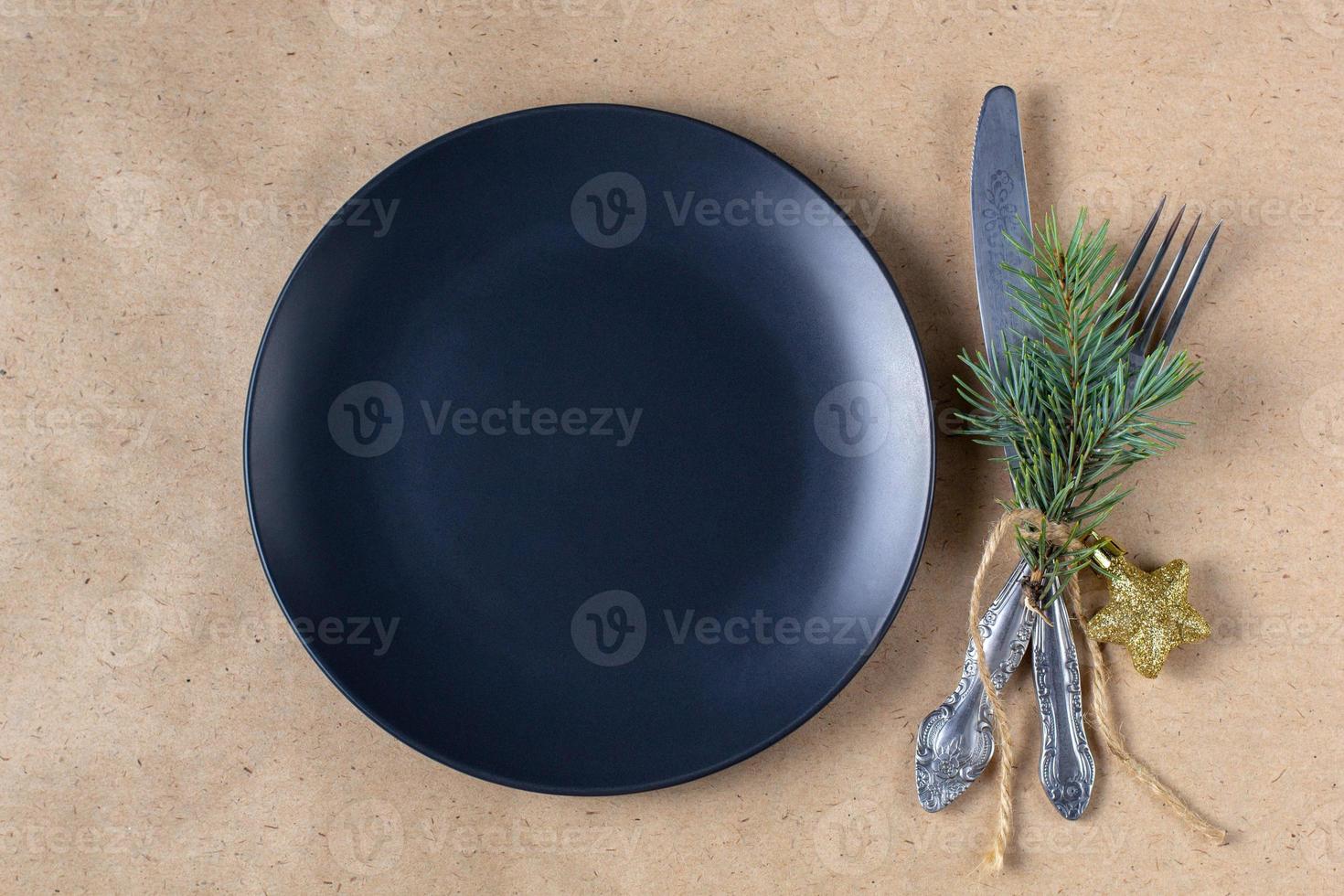 Holiday table setting with branch of christmas tree, empty plate and decorations. New year flat lay food concept photo