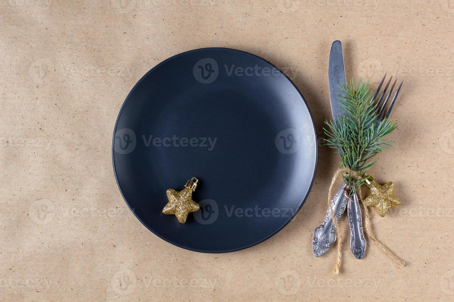 Holiday table setting with branch of christmas tree, empty plate and decorations. New year flat lay food concept photo
