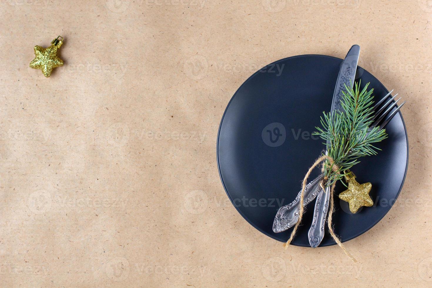 Holiday table setting with branch of christmas tree, empty plate and decorations. New year flat lay food concept photo