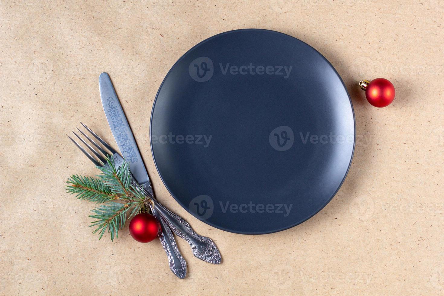 Holiday table setting with branch of christmas tree, empty plate and decorations. New year flat lay food concept photo