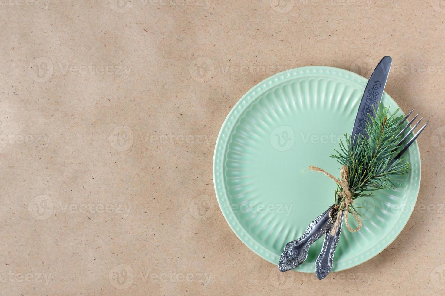 Holiday table setting with branch of christmas tree, empty plate and decorations. New year flat lay food concept photo