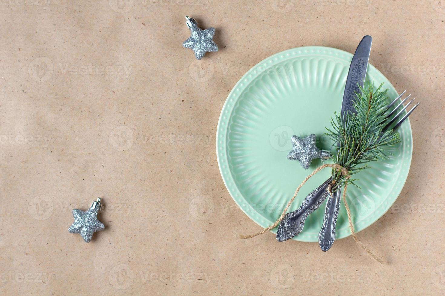 Holiday table setting with branch of christmas tree, empty plate and decorations. New year flat lay food concept photo