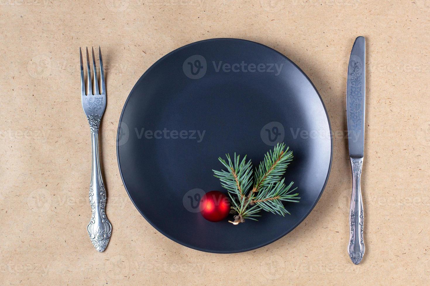 Holiday table setting with branch of christmas tree, empty plate and decorations. New year flat lay food concept photo