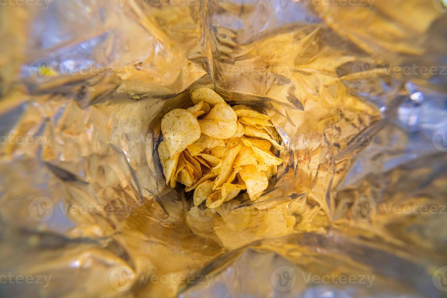 close-up view inside of a big silver bag of potato chips with selective focus photo