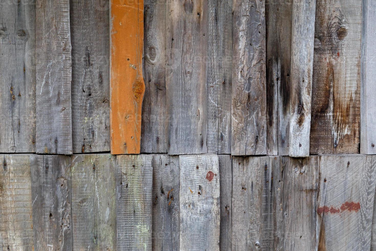 vertical gray messy wooden planks with one brown - wall suface texture and background photo