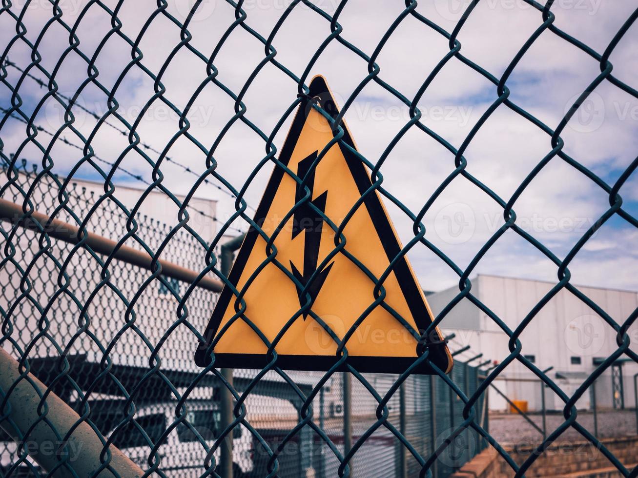 high voltage warning sign on a high-voltage substations mesh fence photo