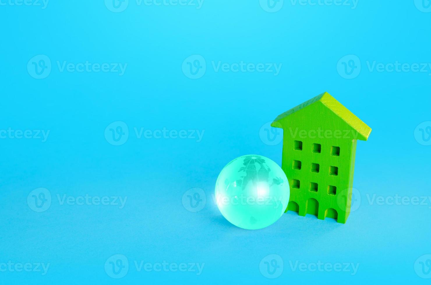 Green multi-storey residential building and blue earth globe. Green technologies. Environmentally friendly, energy efficiency, zero emissions. Carbon neutrality. Communication and networking. Internet photo