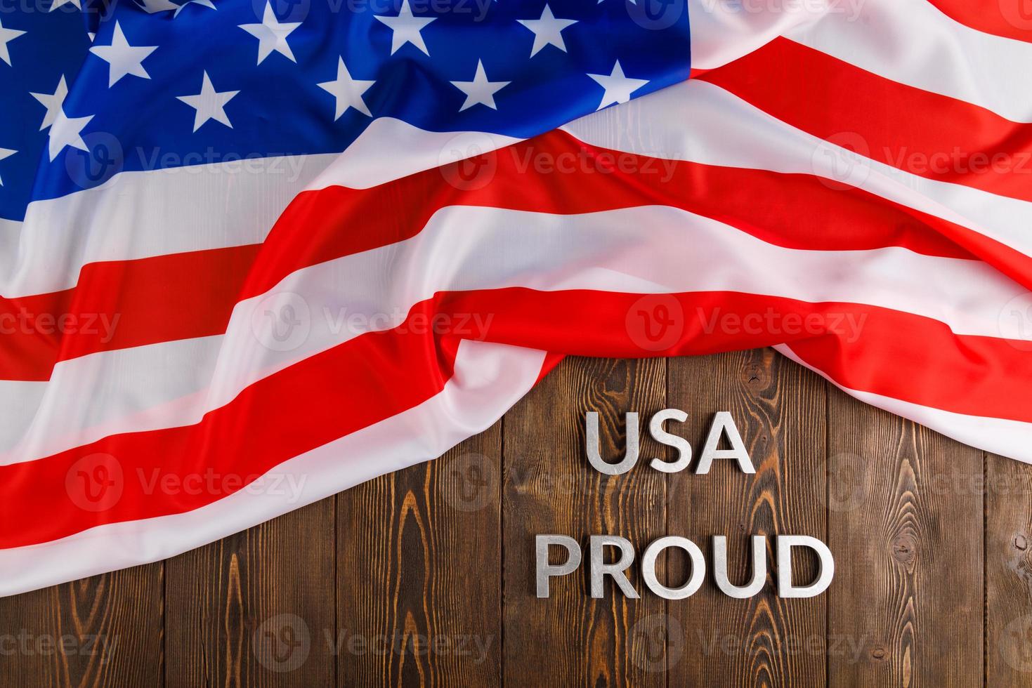 palabras usa orgullo colocadas con letras de metal plateado en una superficie de madera marrón con la bandera de los estados unidos de américa foto