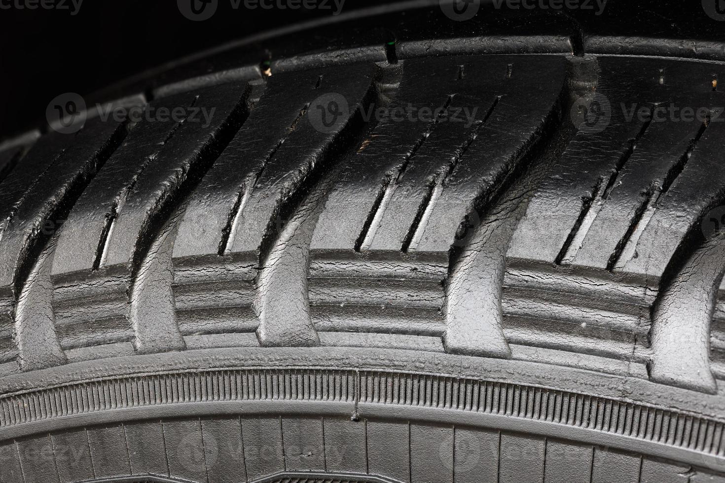 Old worn black tire with many large cracks in the car wheel. photo