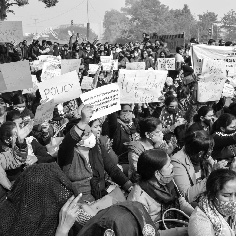 Delhi, India December 25 2021 - Delhi Contractual Guest Teachers with posters, flags and graffitis protesting against Delhi AAP Government for making policy, Delhi Teacher protesting Black and White photo