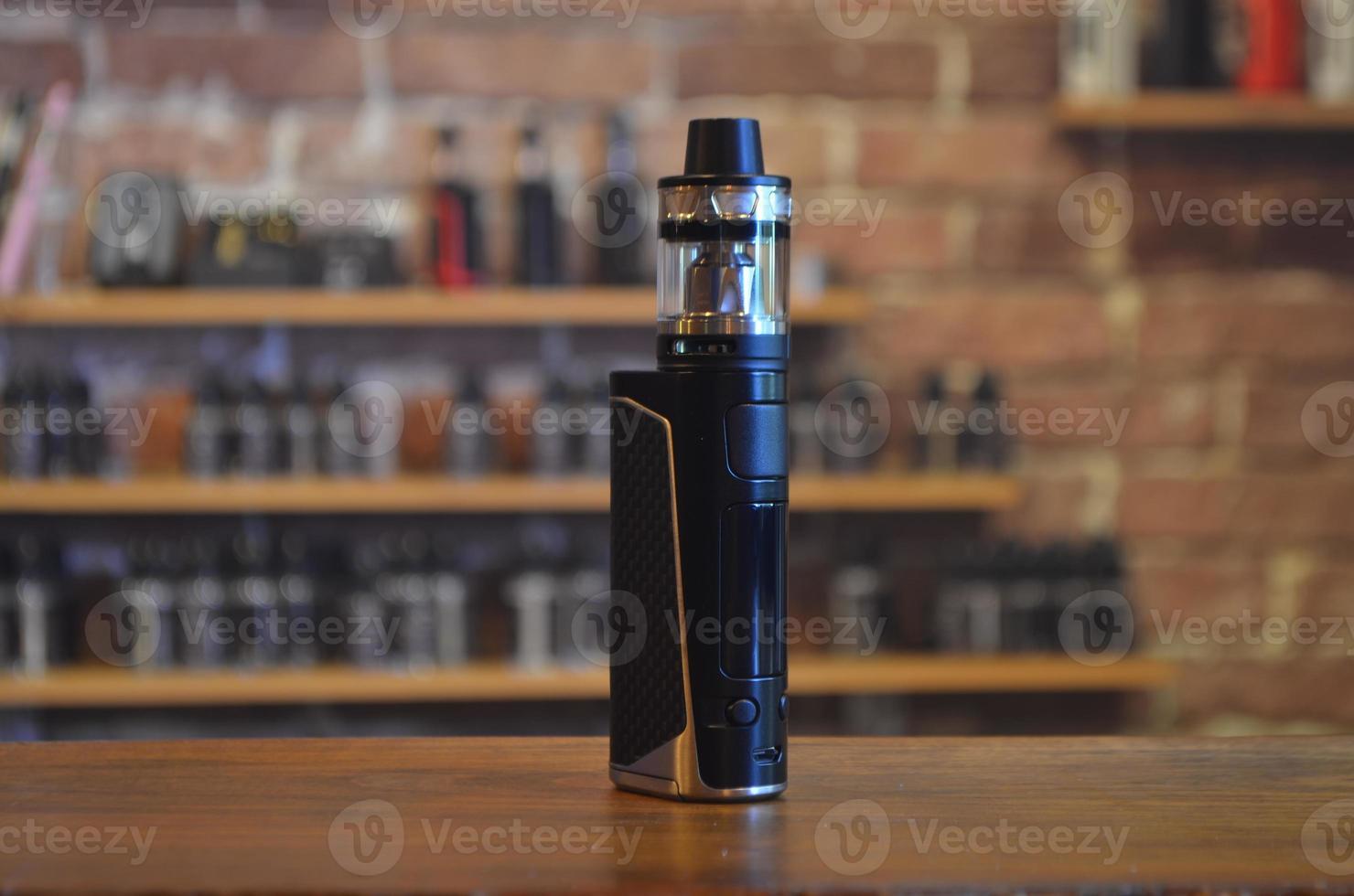 Electronic cigarette on a background of vape shop. E-cigarette for vaping. photo