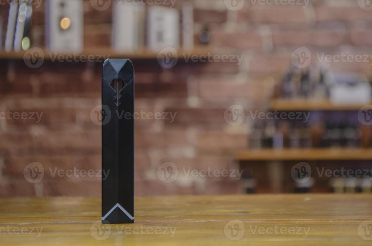 Electronic cigarette on a background of vape shop. E-cigarette for vaping. photo