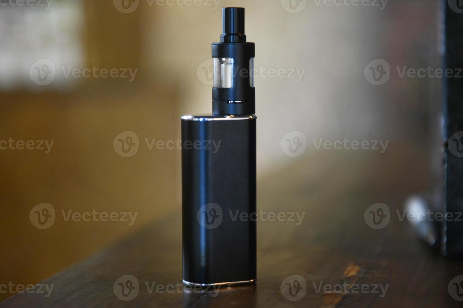 Electronic cigarette on a background of vape shop. E-cigarette for vaping. photo