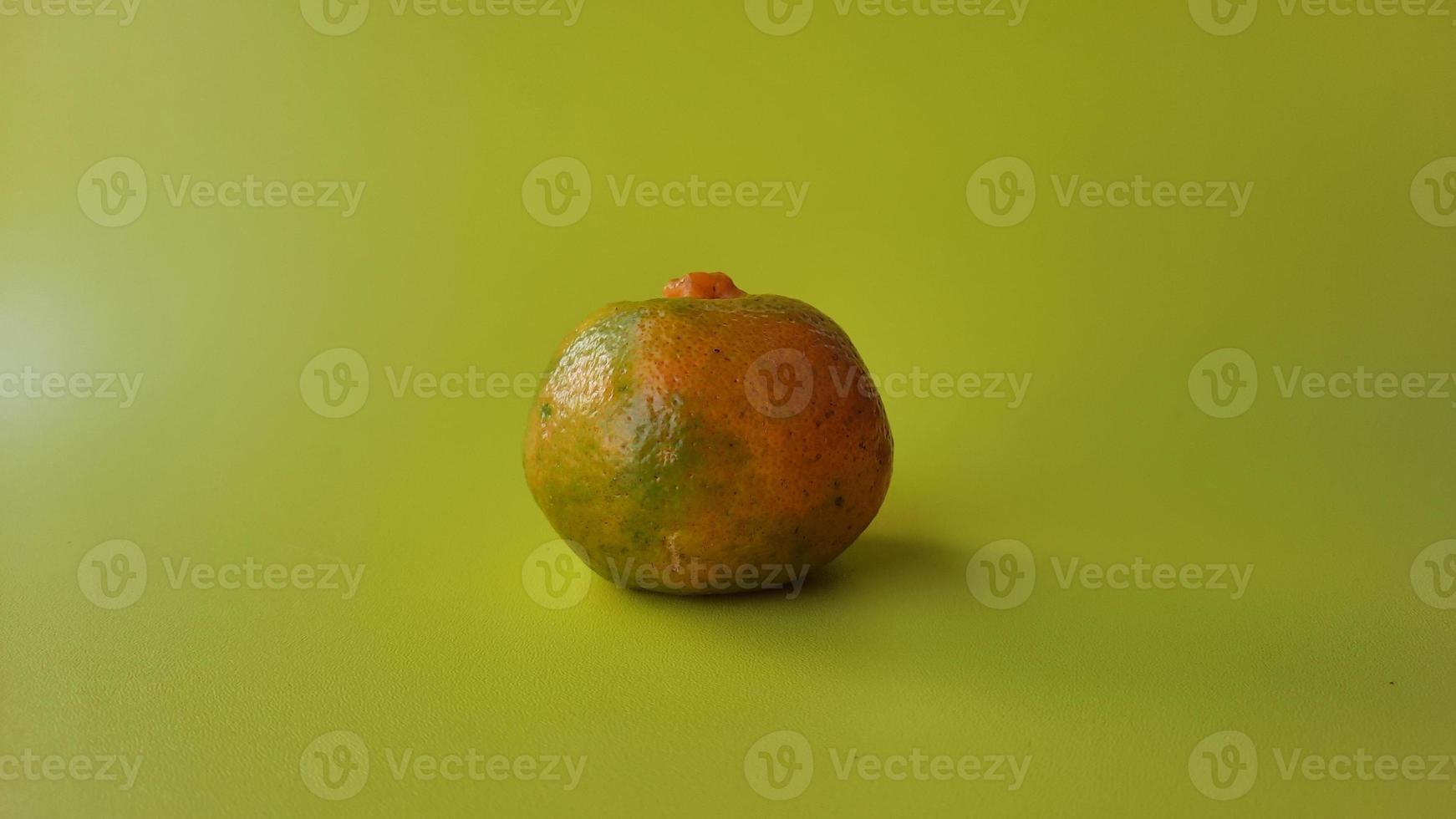 An orange on a yellow background photo