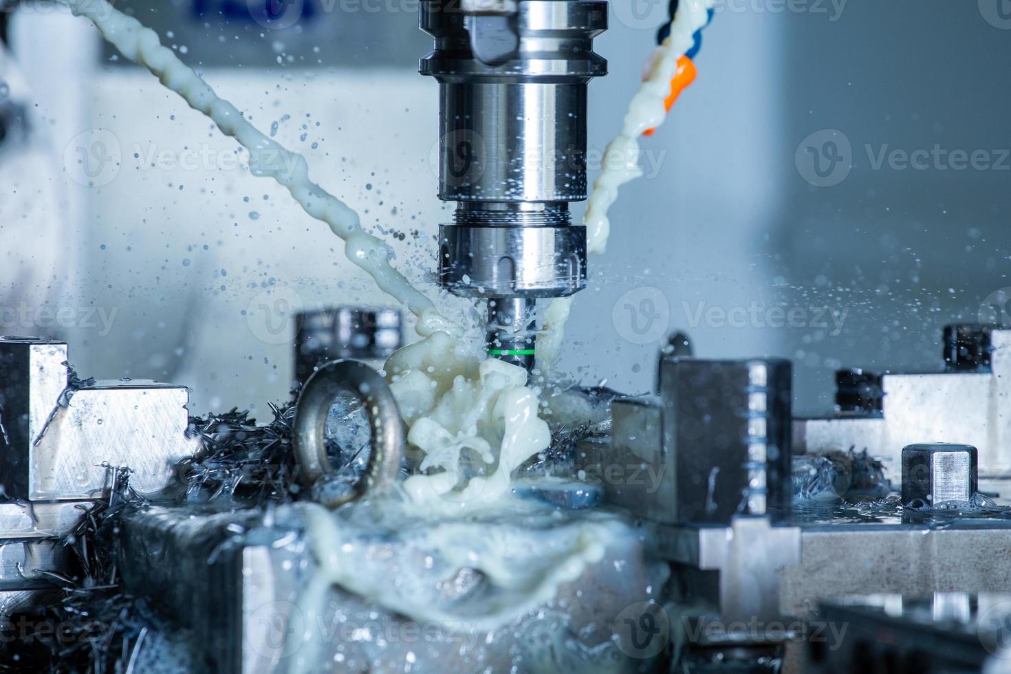 vertical cnc steel milling process with external water coolant streams, splashes and a lot of metal chips, high contrast photo