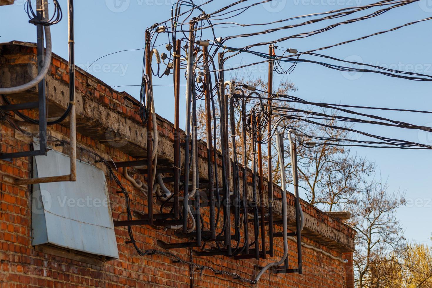 muchos cables que sobresalen de un antiguo edificio de subestación eléctrica de ladrillo foto