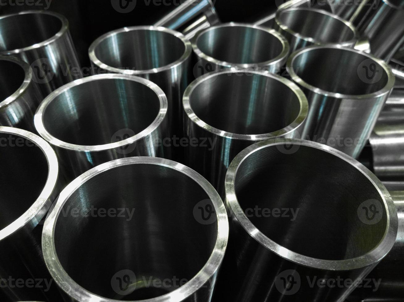 dark industrial background with cnc machined shiny steel pipes - selective focus and lens blur tech photo