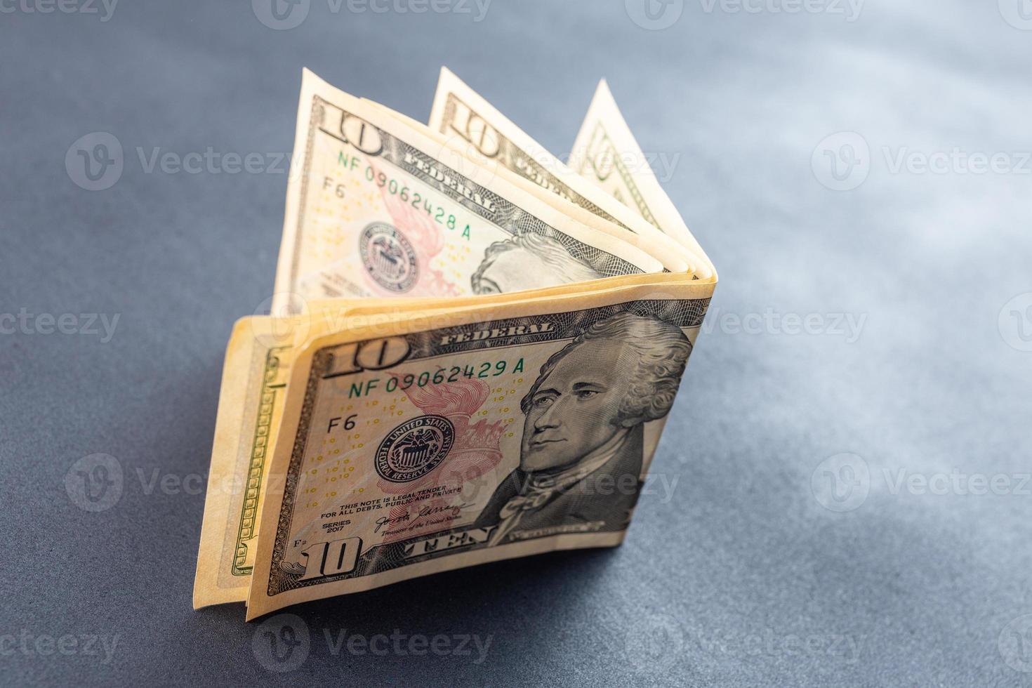 40 dollars on abstract black surface - 4 of 10 dollar banknotes bent and standing photo