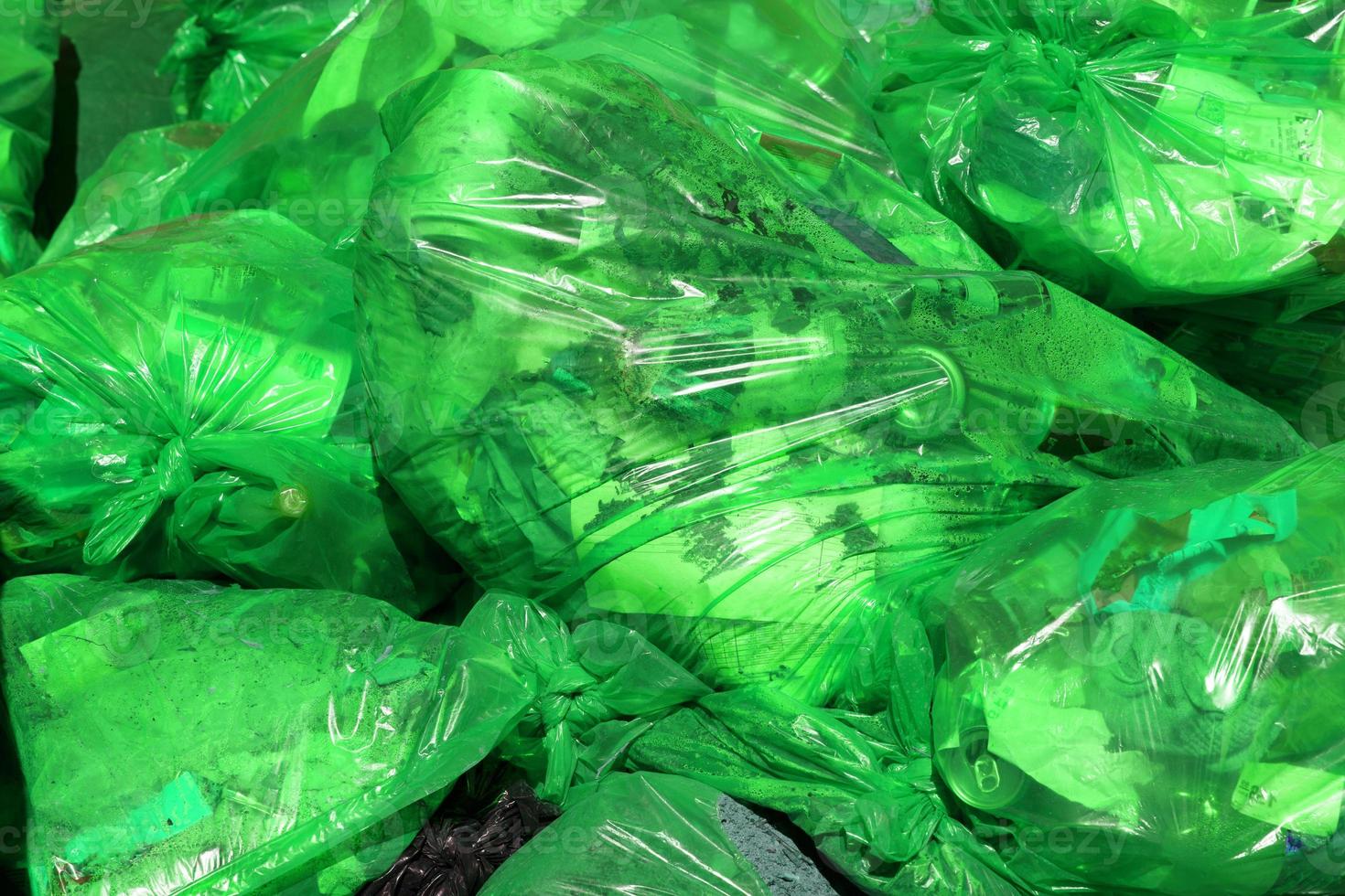 https://static.vecteezy.com/system/resources/previews/012/627/016/non_2x/full-frame-background-of-green-plastic-trash-bags-with-generic-domestic-waste-photo.jpg